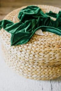 green cloth placed on rattan pouf. Rattan is a natural material