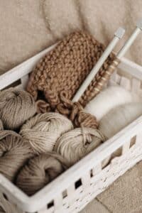white and brown yarns in basket. Yarn made from wool is another type of natural material 