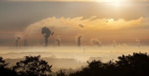 image of pollution in the air coming from multiple stacks from manufacturing facilities